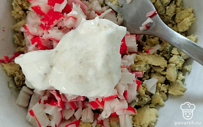 Мелко нарежьте крабовые палочки, добавьте их к желткам. Сюда же добавьте сметану, соль и перец по вкус.