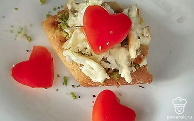 Из помидоров вырежьте сердечки, выложите на тост.