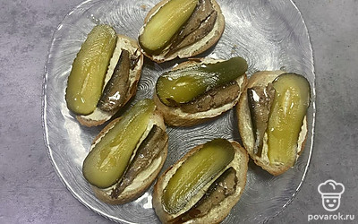 Рядом с огурцом выложите на кусочек хлеба одну рыбку. 