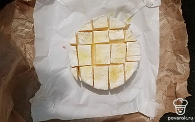 В центр формы поместите подготовленный сыр. Для удобства можете разместить его вместе с бумажной упаковкой.