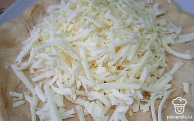 От натертого сулугуни оставьте щепотку. Остальной сыр выложите на тесто.