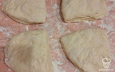 Достаньте тесто из холодильника. Посыпьте стол мукой, разделите тесто на 4 части.