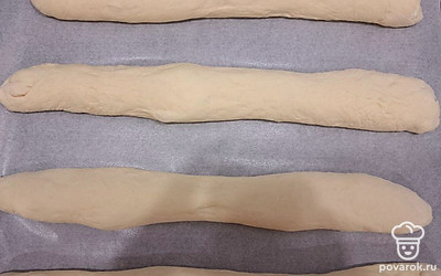Сформируйте четыре багета, выложите их на противень. Желательно застелить его бумагой для выпечки. Оставьте подниматься на 30 минут.