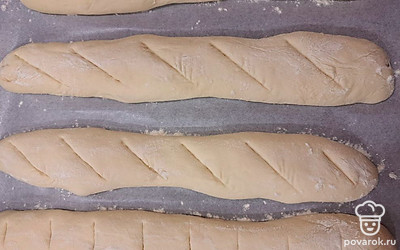 Духовку разогрейте до 220 градусов. На подошедших багетах сделайте надрезы. 