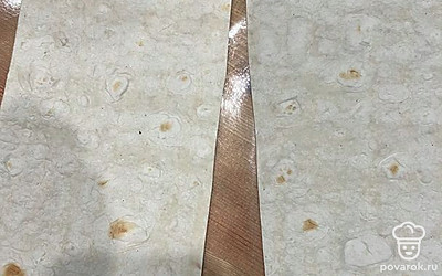 Лаваш разрежьте на ровные полоски шириной примерно 10-12 сантиметров.