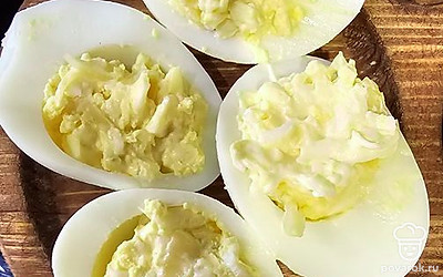 Начините яйца и украсьте зеленью.