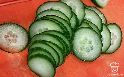 Нарежьте тонко огурец.