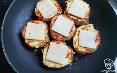 Гренки переверните и на каждую положите по кусочку сыра. 