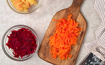 Сварите свеклу, картофель и морковь до мягкости. Натрите овощи на крупной терке.