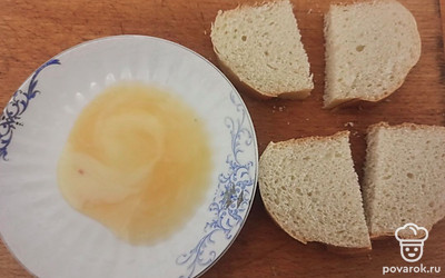 Яйцо взбейте. Хлеб нарежьте на ломтики, разрежьте на половинки. Обмакните с двух сторон в яйцо.