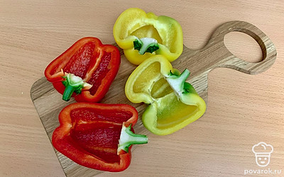 Перец вымойте и разрежьте вдоль пополам. Очистите от семян, не удаляя плодоножку.