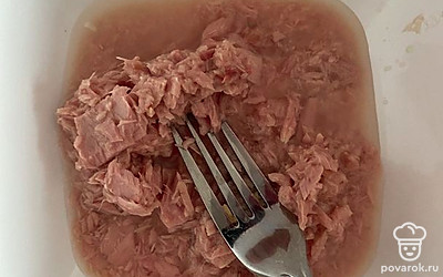 Откройте банку тунца, слейте немного жидкости. Разомните рыбу вилкой.