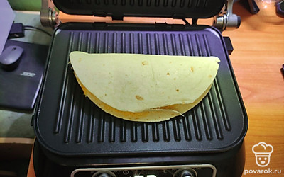 Сложить лепешку пополам, соединяя края. Выложить на гриль и запечь 1 минуту при максимальной температуре.