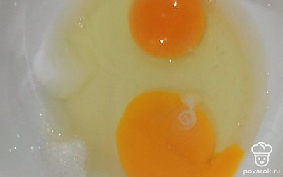 В миску вбить яйца, добавить сахар, соль и перемешать. 