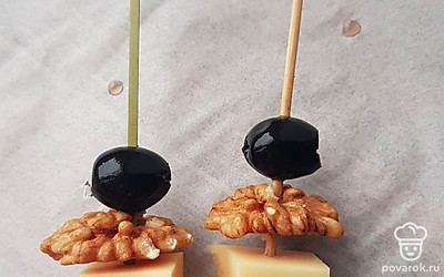 Нанизываем на шпажки маслины, орех и сыр.