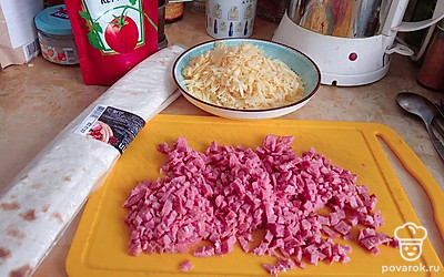 Мелко нарезать колбасу, натереть сыр.