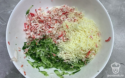 Крабовые палочки и огурец натереть на крупной терке, а сыр натереть на мелкой терке. Смешать ингредиенты в одной миске.