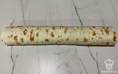 Свернуть лаваш с начинкой в рулет.