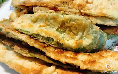 Нарежьте кабачок/цукини слайсами примерно 4-5 миллиметров толщиной. Это можно сделать не только ножом, но и овощечисткой. Нарезайте только саму мякоть кабачка, не трогая сердцевину. Но если кабачок молодой, и семечки мелкие, нарезайте весь кабачок без остатка. Каждый слайс обваляйте в муке (насыпьте муку и соль в целлофановый мешок, туда же отправьте нарезанные кабачки, заверните горлышко пакета и немного потрясите). Разогрейте сковороду с подсолнечным маслом, обжарьте на нем кабачки с двух сторон до золотистой корочки.