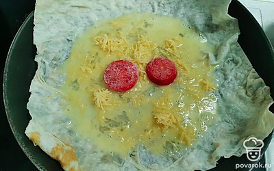 Вылить яйцо, посыпать тертым сыром. Выложить 2-3 кружочка помидора. 