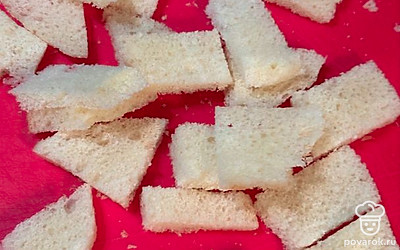 Каждый кусочек хлеба режем на мелкие квадратики.