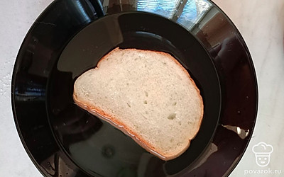 Ломтик хлеба опускаем в тарелку. Смачиваем с двух сторон, немного даем воде стечь, немного отжимаем. 