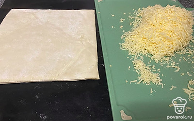 Тесто разморозьте, сыр натрите на мелкой терке.