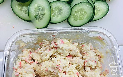 Огурцы нарезать тонкими колечками. На каждый огурчик выложить ложечку салата и красиво разложить для подачи на стол.