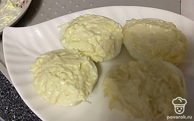 Выложите начинку сверху на яйца.