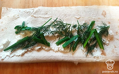 Намажьте лаваш творогом, сверху выложите зелень, нарезанную крупными ломтиками (как на фото).