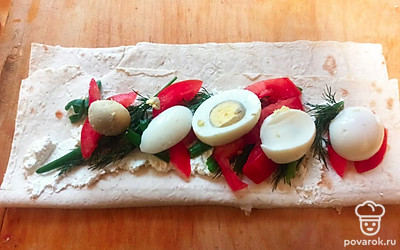 Добавьте помидор и яйцо, посолите по вкусу, сверните в рулет. Дайте настояться 10 минут, чтобы рулет хорошо пропитался.