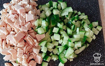 Заранее отваренную курицу и огурцы нарезаем кубиками.