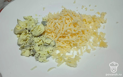 Сыр натрите на терке, желток разомните вилкой, чеснок измельчите.