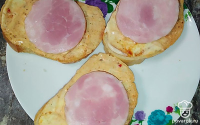 Выложить на хлеб нарезанную кружочками колбасу.