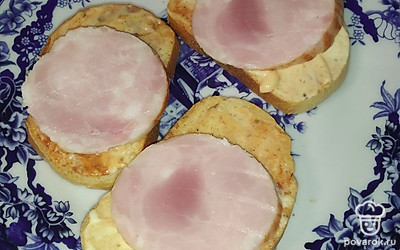 Выложить на хлеб нарезанную колбасу.