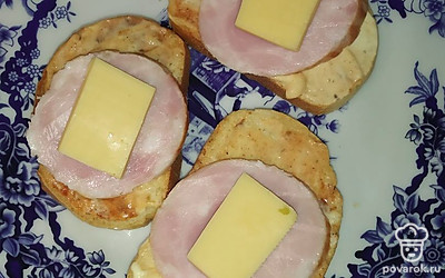 На колбасу положить кусочки сыра. Убрать бутерброды в микроволновку на минуту до расплавления сыра.