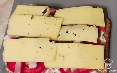 Сверху выложите сыр, нарезанный пластинками, и отправьте в духовку на 7-9 минут.