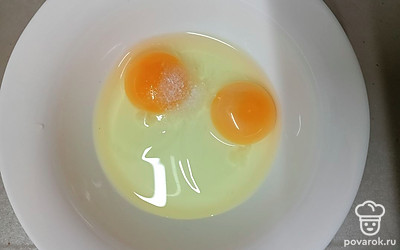 Добавьте к яйцам соль. Можете также положить любые специи, если желаете: перец, сушеный чеснок, паприку.