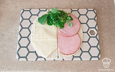 Начинку выложите по очереди. Сначала ветчина, затем салат и плавленый сыр.