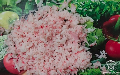 Крабовые палочки натираем на терке, половину откладываем. 