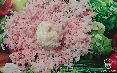 Из этой смеси скатаем небольшие шарики и обваляем их в оставшихся крабовых палочках. Выложим на тарелку готовые «Рафаэлло».