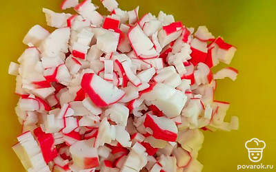 Крабовые палочки нашинковать.