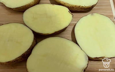 Разрежьте клубни картофеля на две части. На каждом клубне сделайте надрезы ножом и посолите.