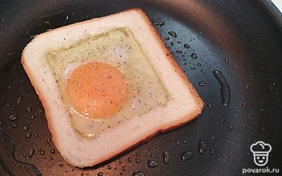 Из 2 кусков тостового хлеба вынуть серединки, положить на разогретую сковороду с небольшим количеством масла и вбить по 1 яйцу. 