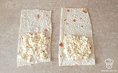 На лаваш выложите подготовленную начинку. Распределите примерно до середины лаваша. 