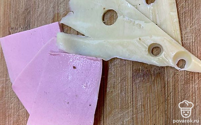 Нарежьте слайсами сыр и вареную колбасу.