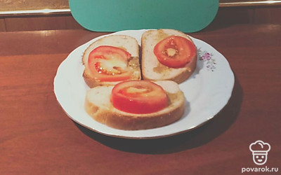 Смазать хлеб тонким слоем горчицы. Нарезать помидор ломтиками. Уложить на хлеб.