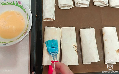 Укладываем на противень и смазываем яйцом.