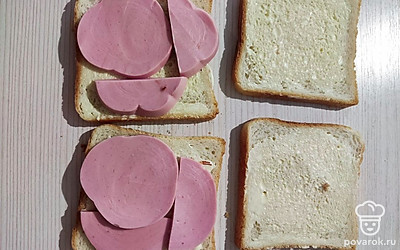 На 2 ломтика хлеба выложить колбасу.