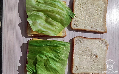 Последним выложить лист салата. Накрыть сверху оставшимися ломтиками хлеба.
